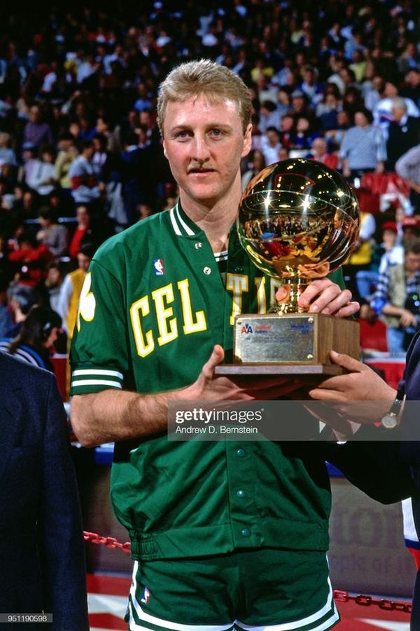 Larry Bird of the Boston Celtics poses with the trophy after winning...